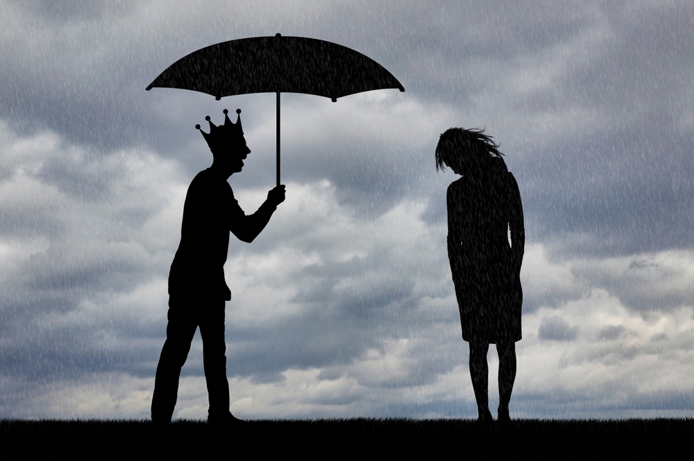 A silhouette of a person wearing a crown holds an umbrella in the rain. The scene suggests the isolation often felt during narcissistic abuse in relationships.