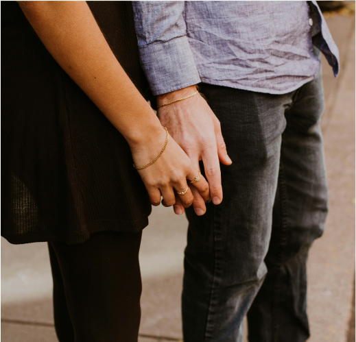 Two people stand side by side, holding hands capturing a moment of connection often nurtured through online couple therapy.
