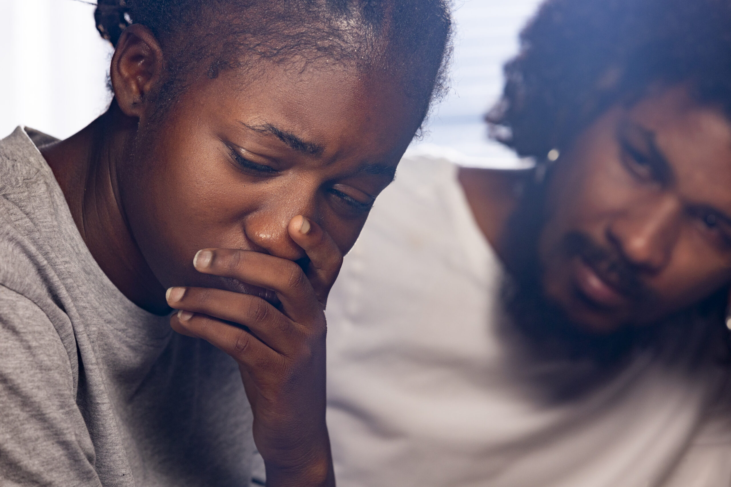 A woman appears distressed, while a man beside her looks on with concern suggesting they may be seeking counselling for infidelity.